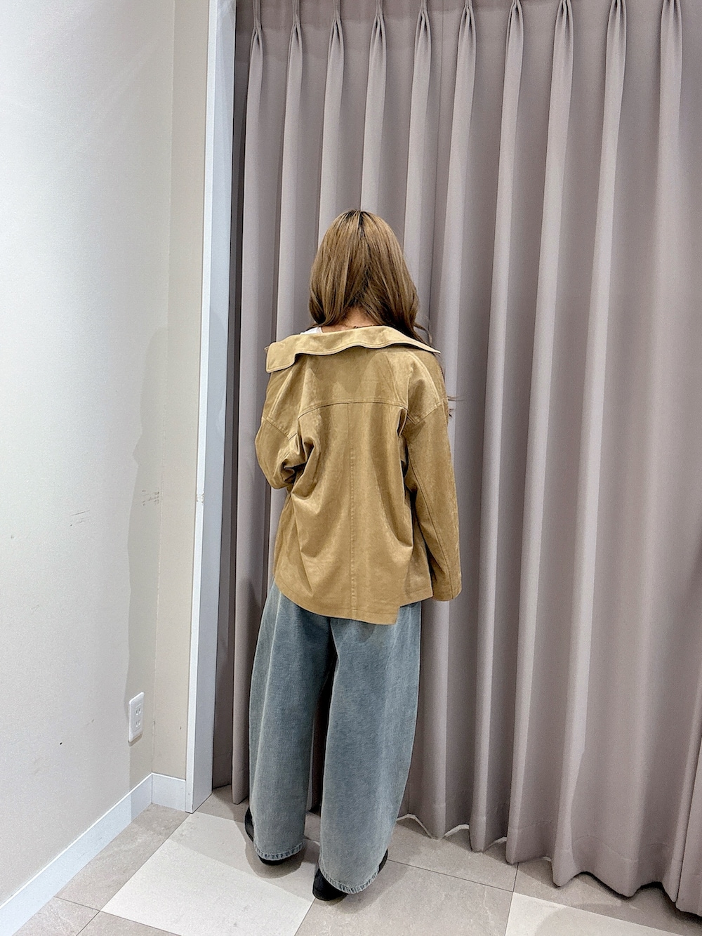 ブルー系のデニムパンツ、ホワイト系のタンクトップ、ベージュ系のその他アウターを着用したレディースの春コーディネートの3枚目の写真