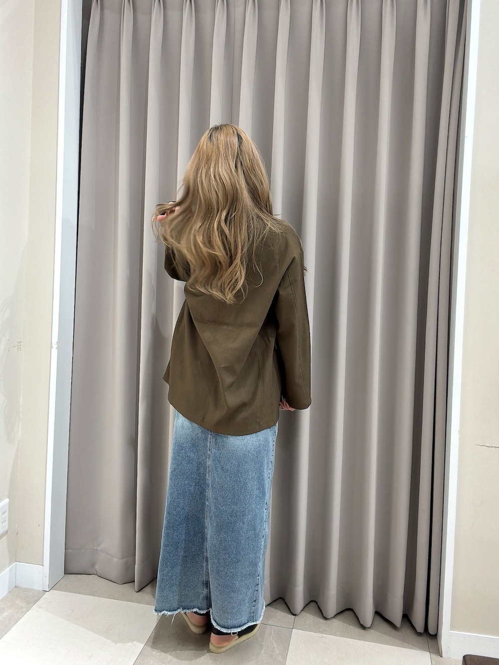 ブルー系のスカート、ホワイト系のタンクトップ、ブラウン系のその他アウターを着用したレディースの春コーディネートの2枚目の写真