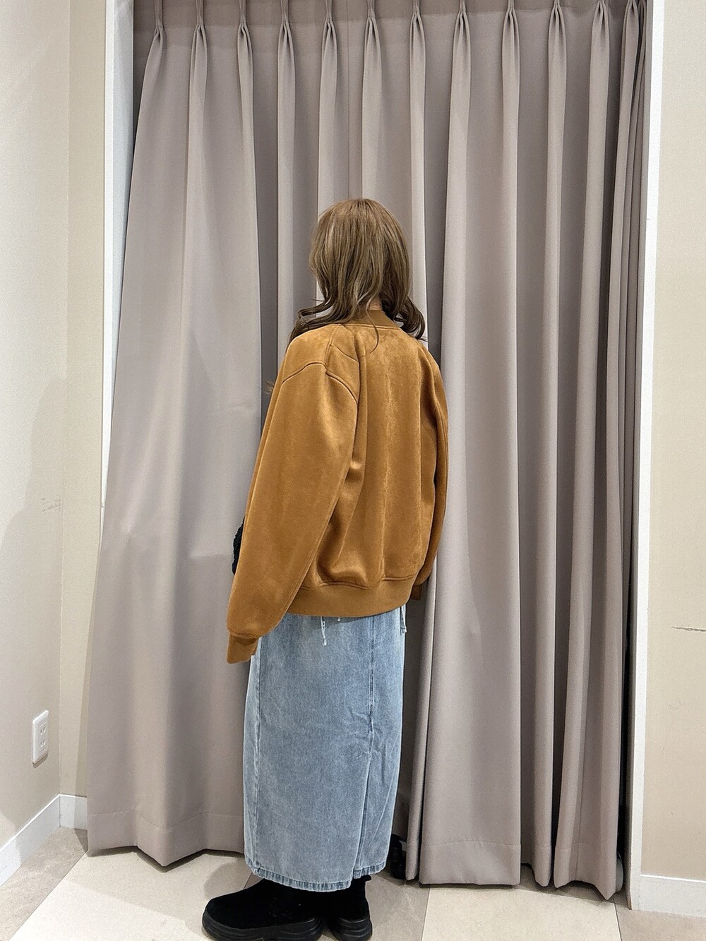 ブラック系のニット/セーター、ブラウン系のブルゾン、ブルー系のワンピースを着用したレディースの冬コーディネートの3枚目の写真