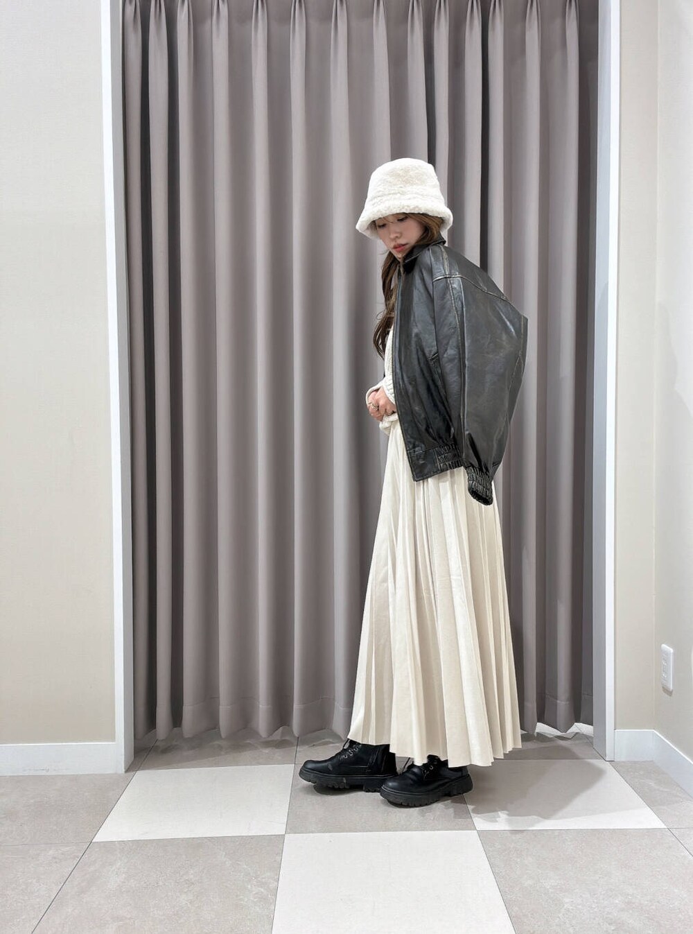 ホワイト系のショルダーバッグ、ベージュ系のスカート、ブラウン系のその他アウターを着用したレディースの秋コーディネートの2枚目の写真