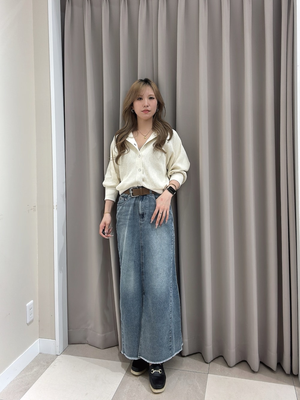 ホワイト系のカーディガン/ボレロ、ブルー系のスカート、ブラック系のその他シューズを着用したレディースの春コーディネートの2枚目の写真