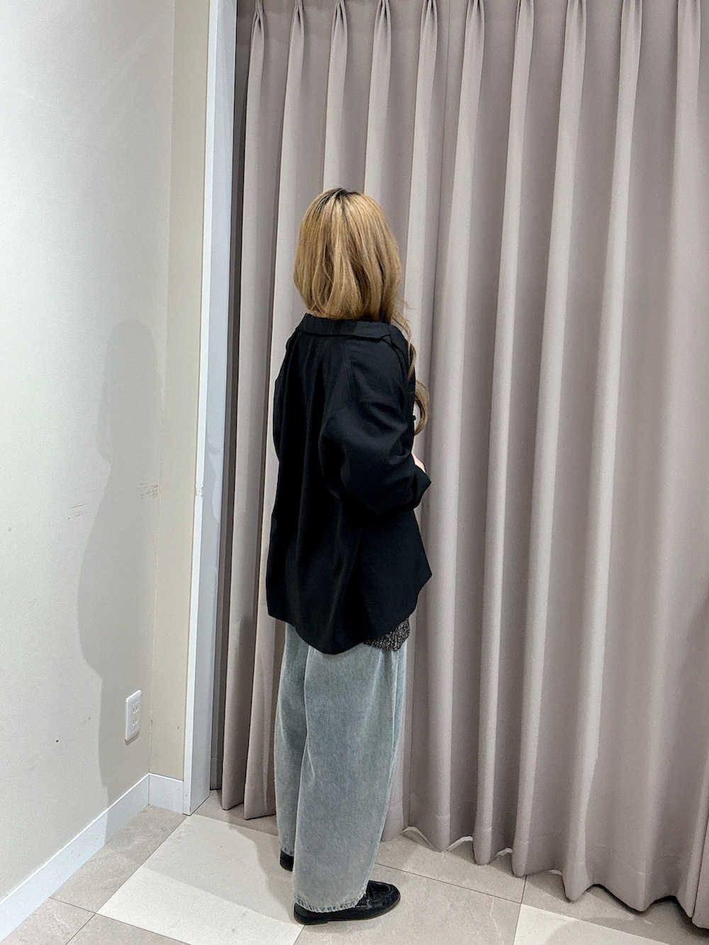 ブルー系のデニムパンツ、ブラック系のベスト、ブラック系のその他アウターを着用したレディースの春コーディネートの2枚目の写真