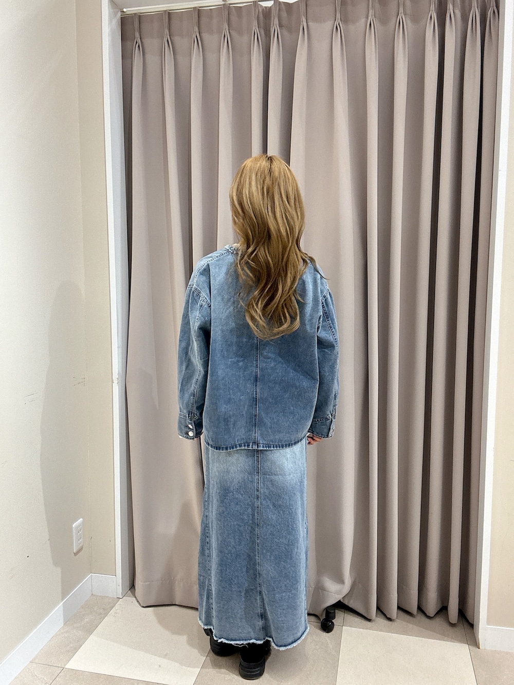 ブルー系のスカート、ホワイト系のニット/セーター、ブルー系のデニムジャケットを着用したレディースの冬コーディネートの3枚目の写真