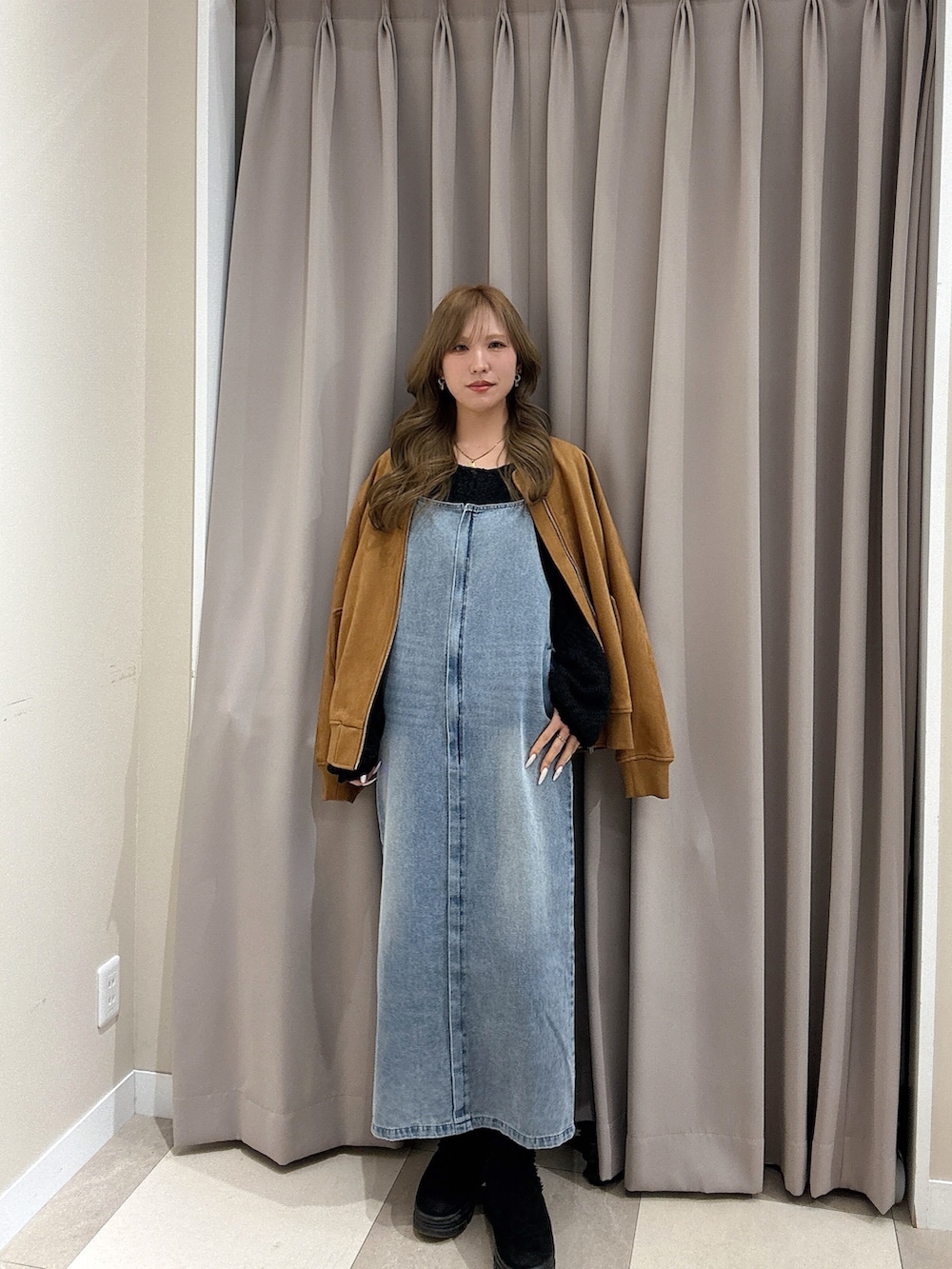 ブラック系のニット/セーター、ブラウン系のブルゾン、ブルー系のワンピースを着用したレディースの冬コーディネートの2枚目の写真