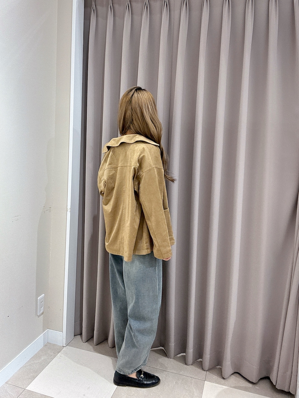 ブルー系のデニムパンツ、ホワイト系のタンクトップ、ベージュ系のその他アウターを着用したレディースの春コーディネートの2枚目の写真