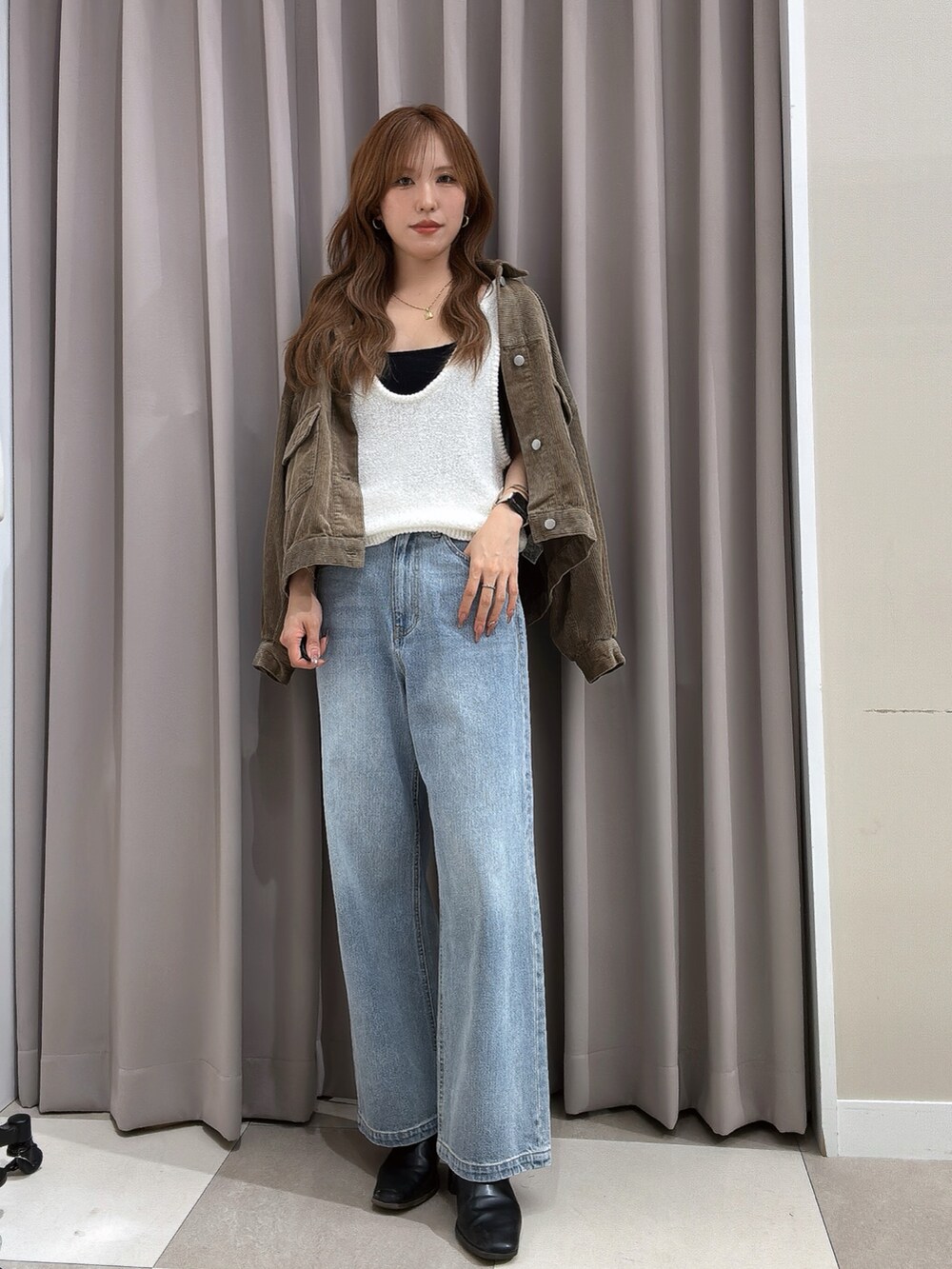 ベージュ系のその他アウター、ブルー系のデニムパンツ、ホワイト系のベストを着用したレディースの秋コーディネートの2枚目の写真