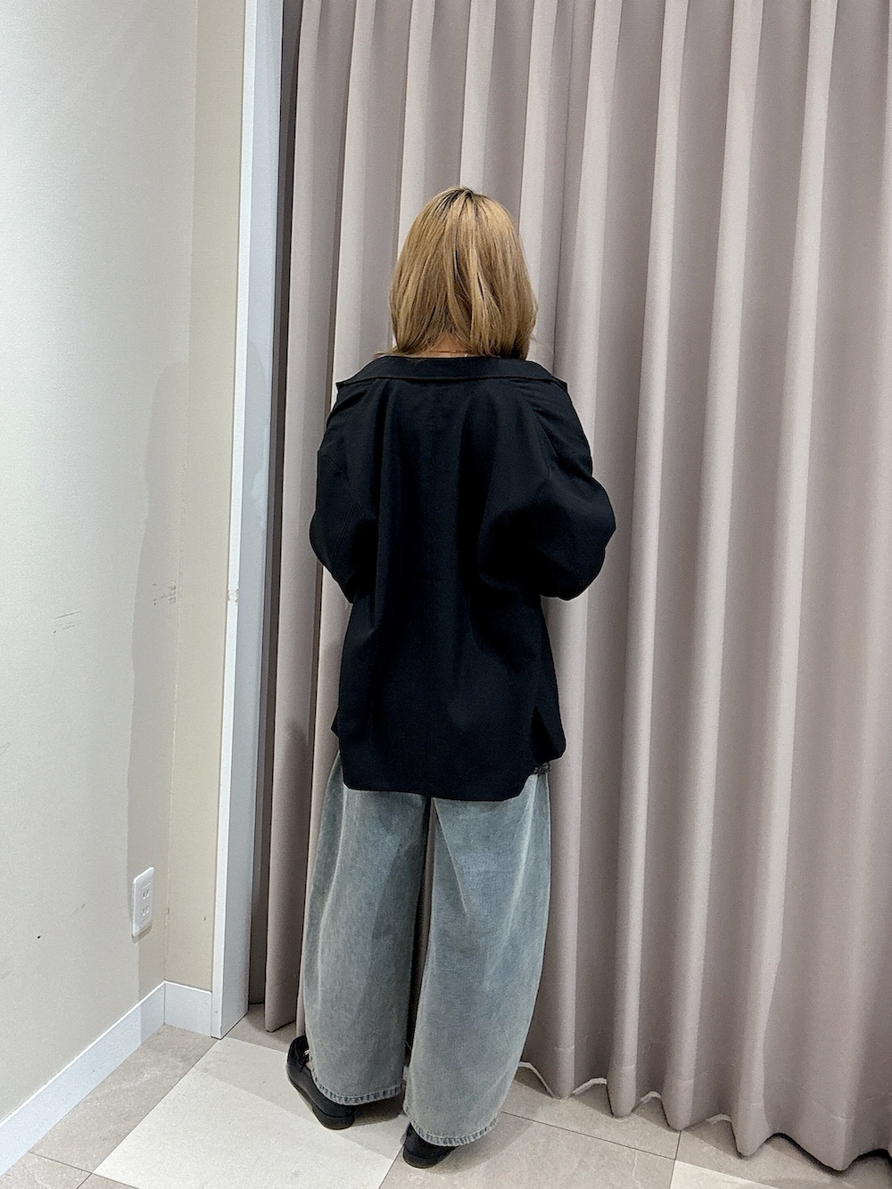 ブルー系のデニムパンツ、ブラック系のベスト、ブラック系のその他アウターを着用したレディースの春コーディネートの3枚目の写真