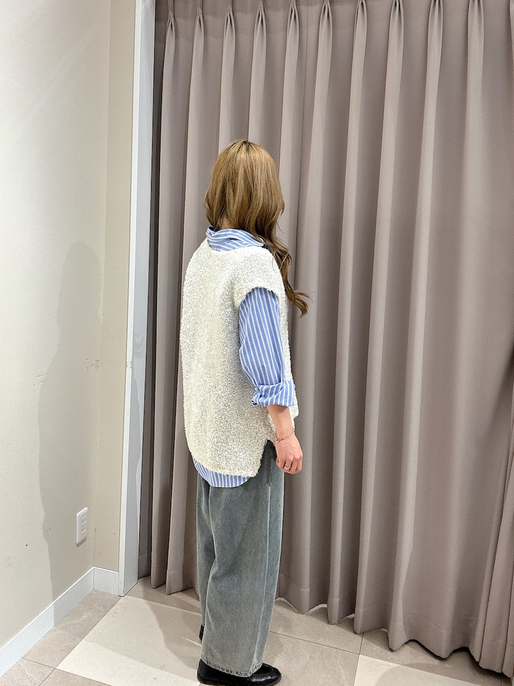 ブルー系のデニムパンツ、ブルー系のシャツ/ブラウス、ホワイト系のニット/セーターを着用したレディースの春コーディネートの2枚目の写真