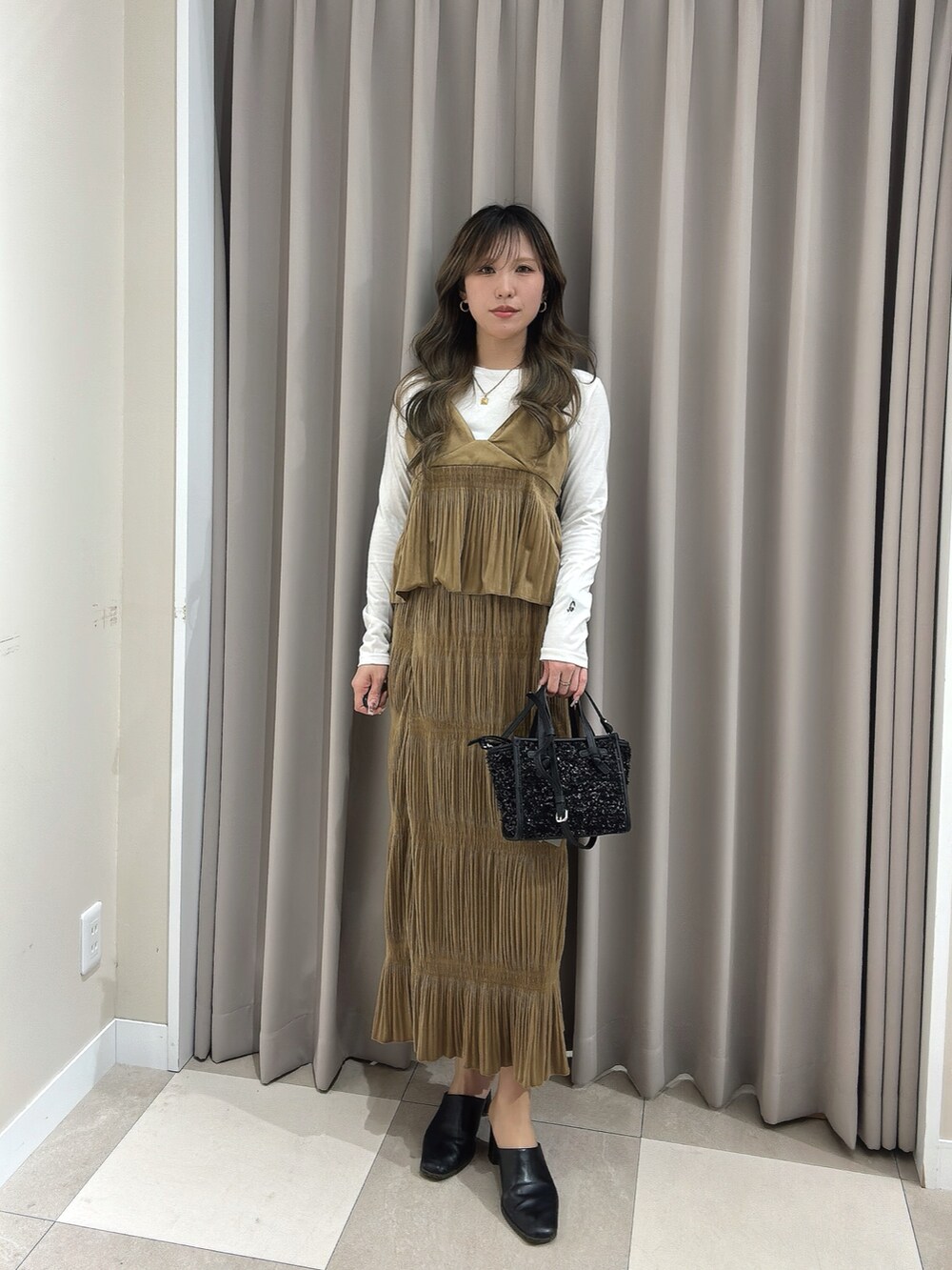 ホワイト系のTシャツ/カットソー、ブラック系のハンドバッグ、イエロー系のワンピースを着用したレディースの春コーディネートの2枚目の写真