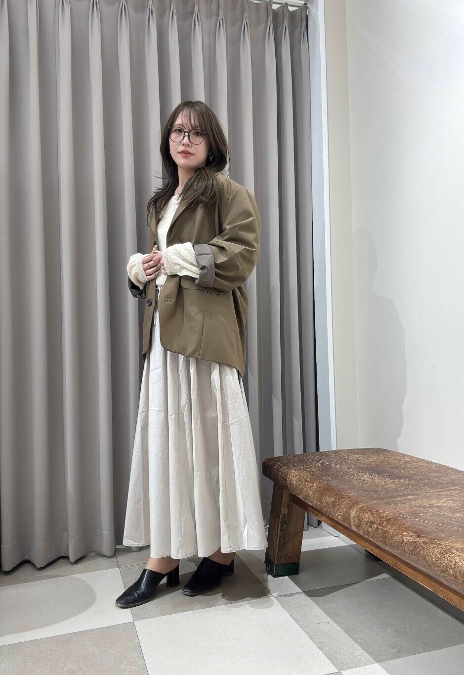 ブラウン系のその他アウター、ホワイト系のスカート、ホワイト系のニット/セーターを着用したレディースの春コーディネートの2枚目の写真