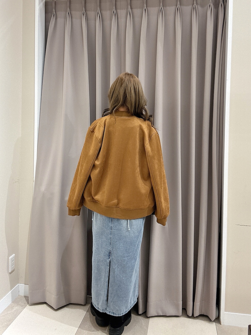 ブラック系のニット/セーター、ブラウン系のブルゾン、ブルー系のワンピースを着用したレディースの冬コーディネートの4枚目の写真