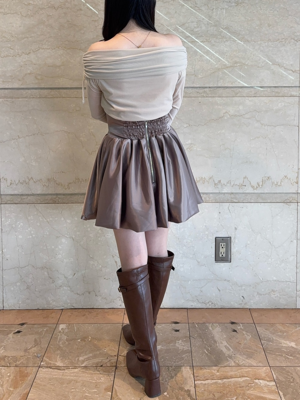 ブラウン系のスカート、ベージュ系のTシャツ/カットソー、ブラウン系のブーツを着用したレディースの冬コーディネートの4枚目の写真