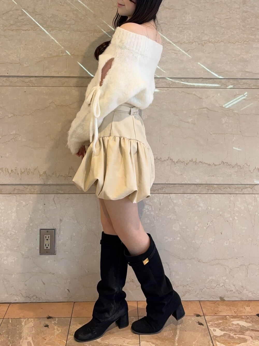 ホワイト系のニット/セーター、ブラック系のブーツ、ホワイト系のその他パンツを着用したレディースの冬コーディネートの3枚目の写真