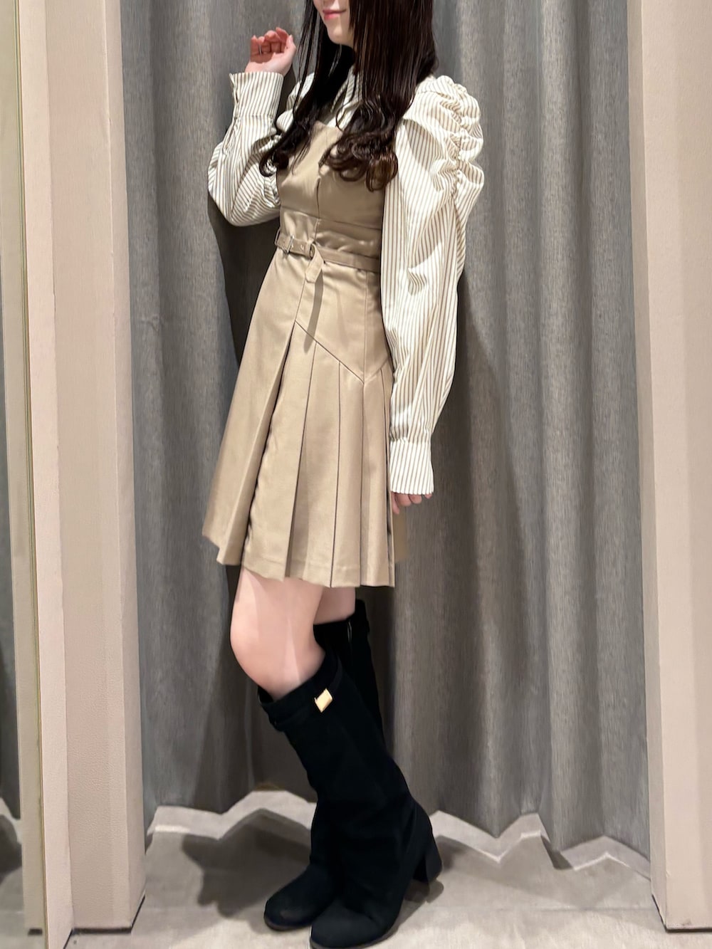 ベージュ系のワンピース、ブラック系のブーツを着用したレディースの秋コーディネートの2枚目の写真