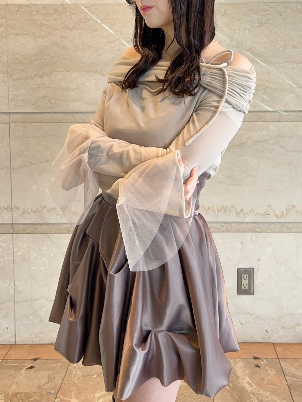 ブラウン系のスカート、ベージュ系のTシャツ/カットソー、ブラウン系のブーツを着用したレディースの冬コーディネートの5枚目の写真