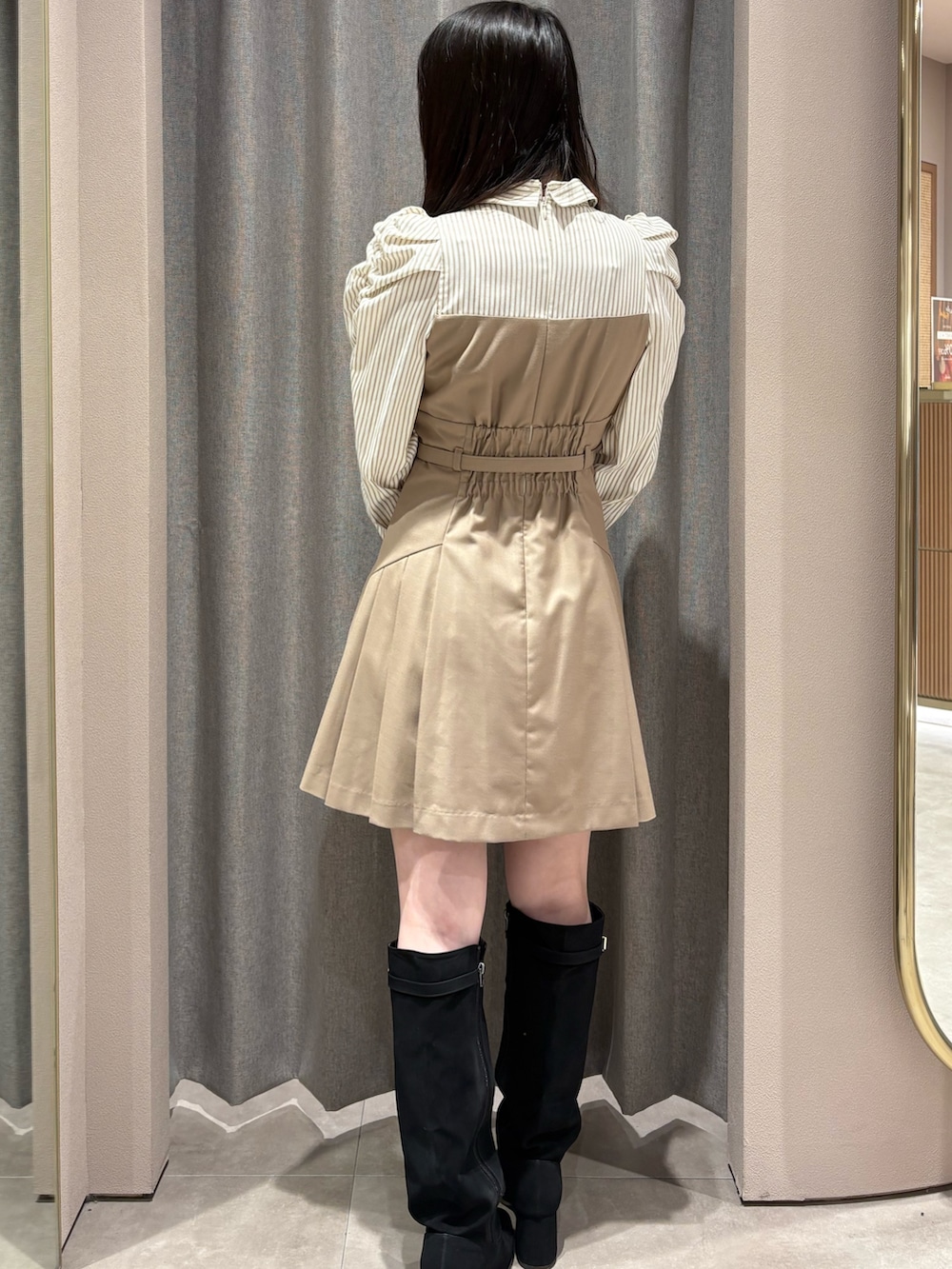 ベージュ系のワンピース、ブラック系のブーツを着用したレディースの秋コーディネートの3枚目の写真