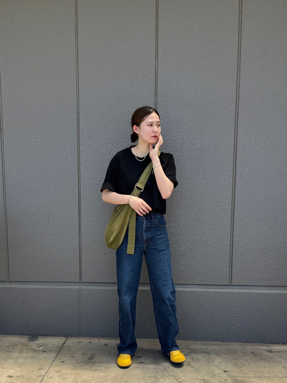 ブラック系のTシャツ/カットソー、ブルー系のデニムパンツ、イエロー系のスニーカーを着用したレディースの春コーディネートの2枚目の写真