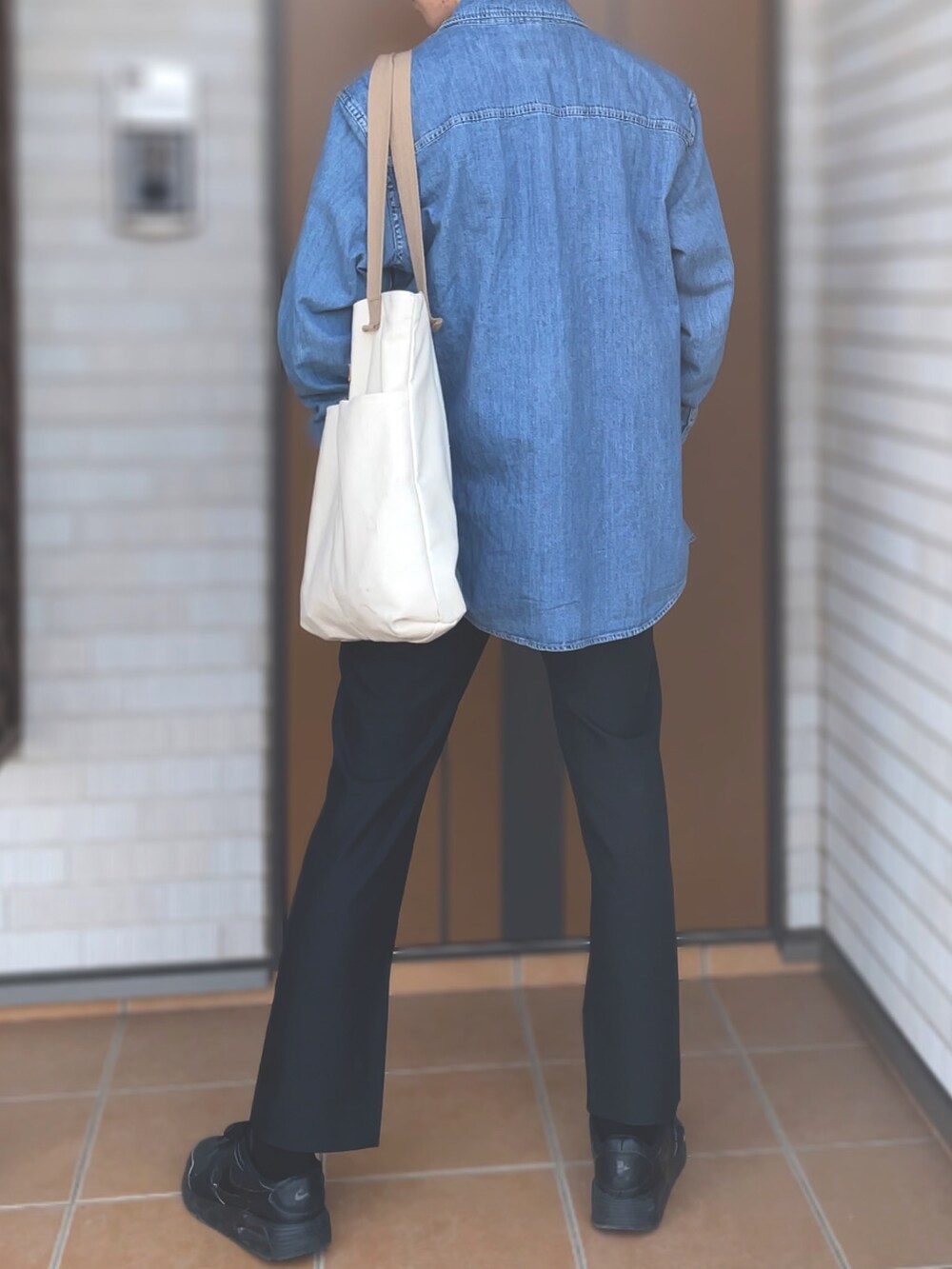 ブルー系のデニムジャケット、ホワイト系のTシャツ/カットソー、ブラック系のスラックスを着用したメンズの春コーディネートの2枚目の写真