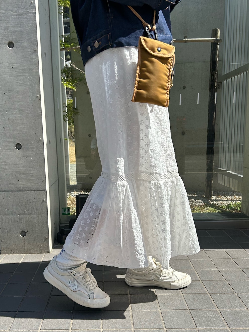 ホワイト系のTシャツ/カットソー、ホワイト系のスカート、ブルー系のデニムジャケットを着用したレディースの春コーディネートの4枚目の写真