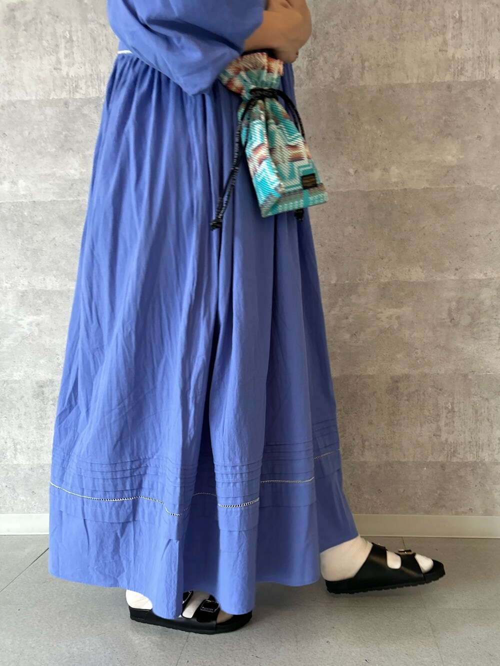 ブルー系のワンピース、ホワイト系のTシャツ/カットソー、ブルー系のショルダーバッグを着用したレディースの春コーディネートの3枚目の写真