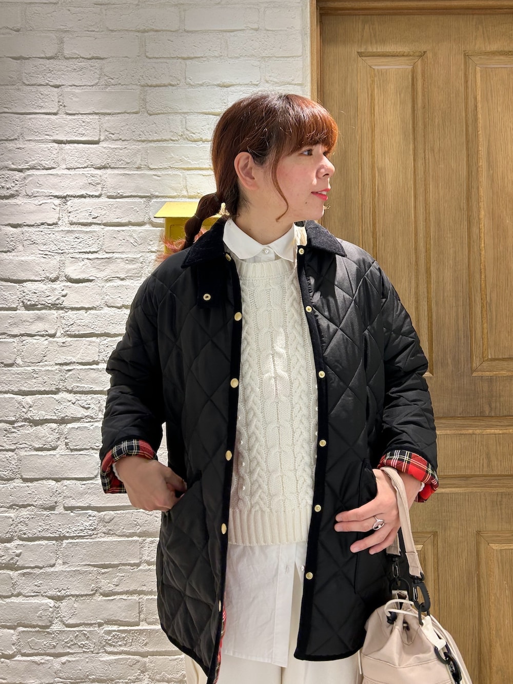 ブラック系のローファー、ホワイト系のシャツ/ブラウス、ホワイト系のニット/セーターを着用したレディースの冬コーディネートの2枚目の写真