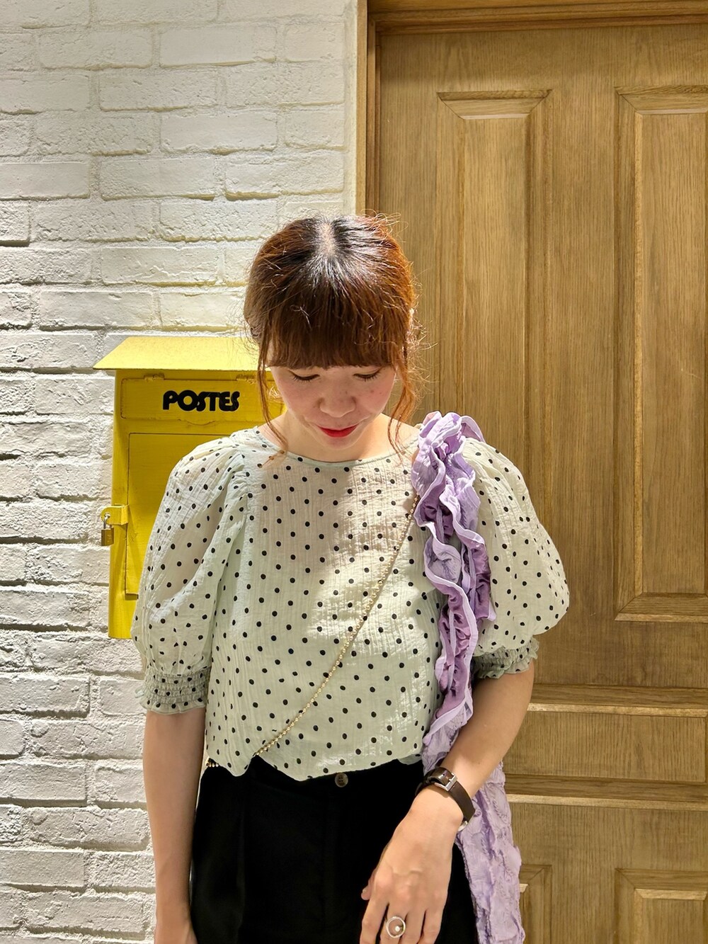 グリーン系のシャツ/ブラウス、ブラック系のスラックス、パープル系のトートバッグを着用したレディースの夏コーディネートの2枚目の写真