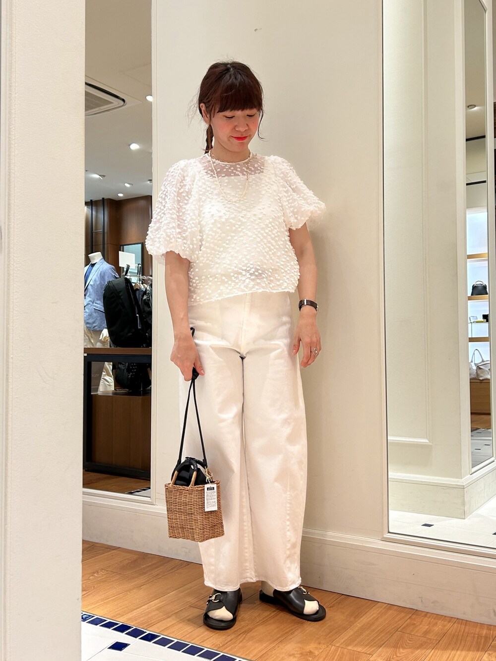 イエロー系のかごバッグ、ホワイト系のデニムパンツ、ホワイト系のシャツ/ブラウスを着用したレディースの春コーディネートの2枚目の写真