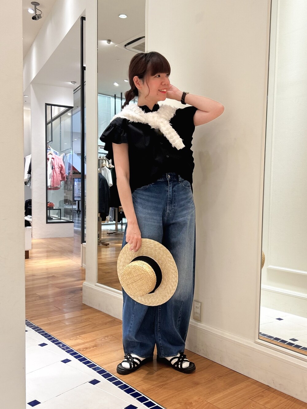 ブルー系のデニムパンツ、ブラック系のシャツ/ブラウス、ホワイト系のカーディガン/ボレロを着用したレディースの春コーディネートの2枚目の写真