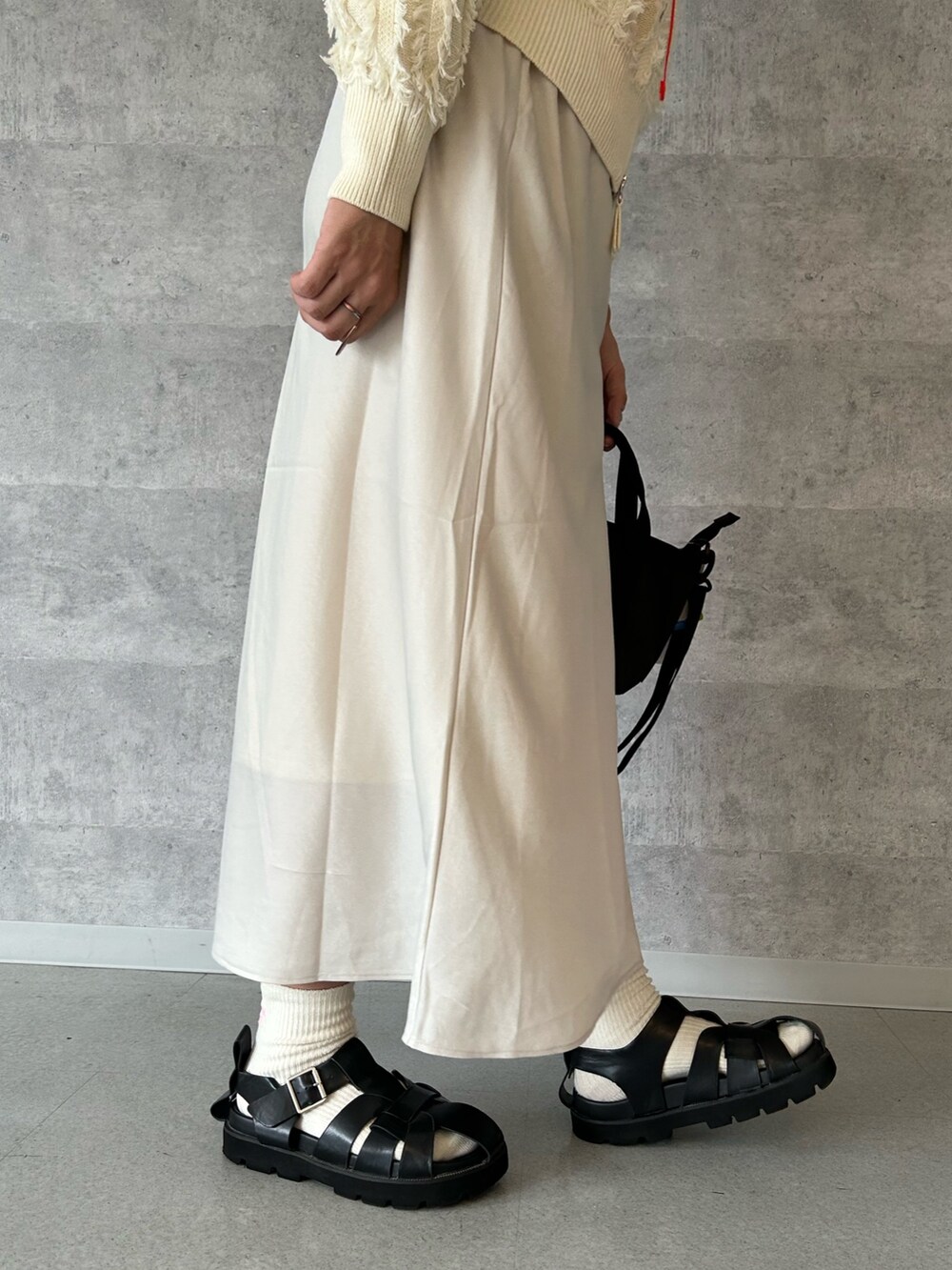 ベージュ系のスカート、ホワイト系のカーディガン/ボレロ、ブルー系のデニムジャケットを着用したレディースの秋コーディネートの4枚目の写真