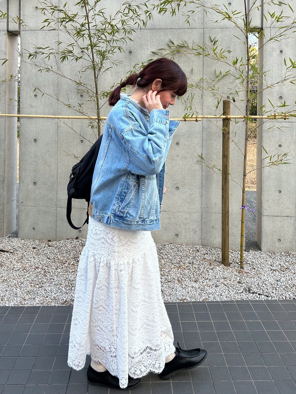 ブルー系のデニムジャケット、ブルー系のスウェット、ブラック系のバックパック/リュックを着用したレディースの冬コーディネートの3枚目の写真