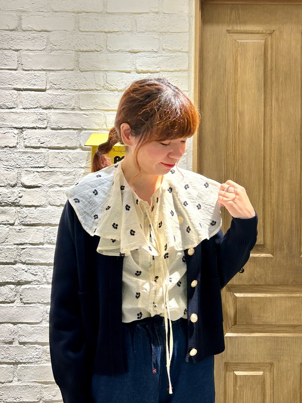 ブルー系のデニムパンツ、ブルー系のカーディガン/ボレロ、ホワイト系のシャツ/ブラウスを着用したレディースの秋コーディネートの2枚目の写真