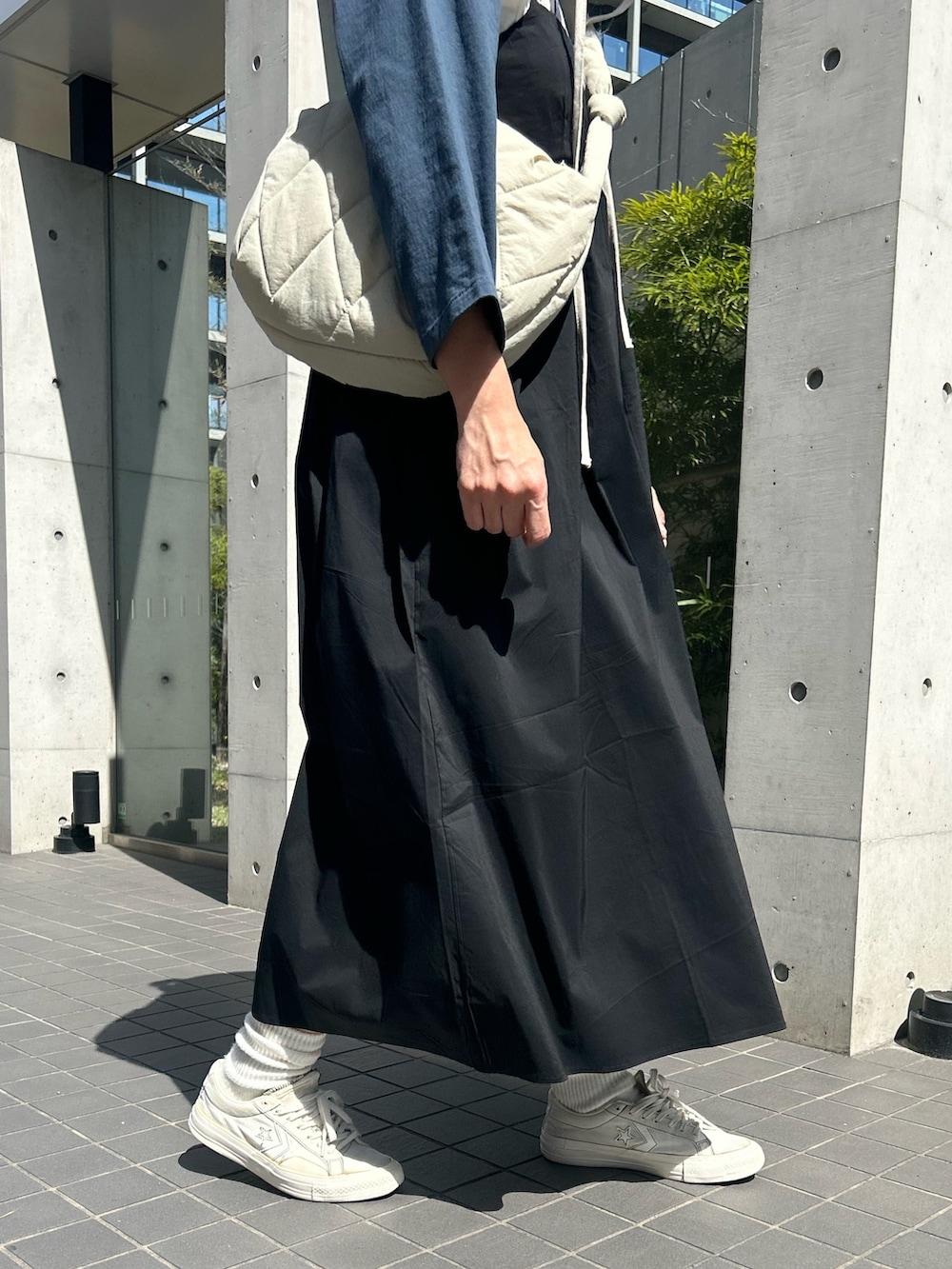 ホワイト系のショルダーバッグ、ホワイト系のTシャツ/カットソー、ブラック系のワンピースを着用したレディースの春コーディネートの4枚目の写真