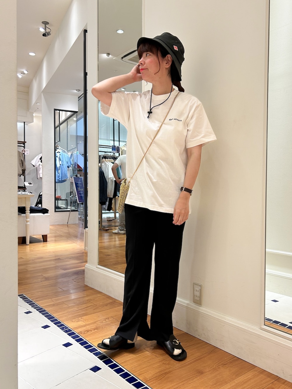 ホワイト系のTシャツ/カットソー、ゴールド系のショルダーバッグ、ブラック系のその他パンツを着用したレディースの春コーディネートの3枚目の写真