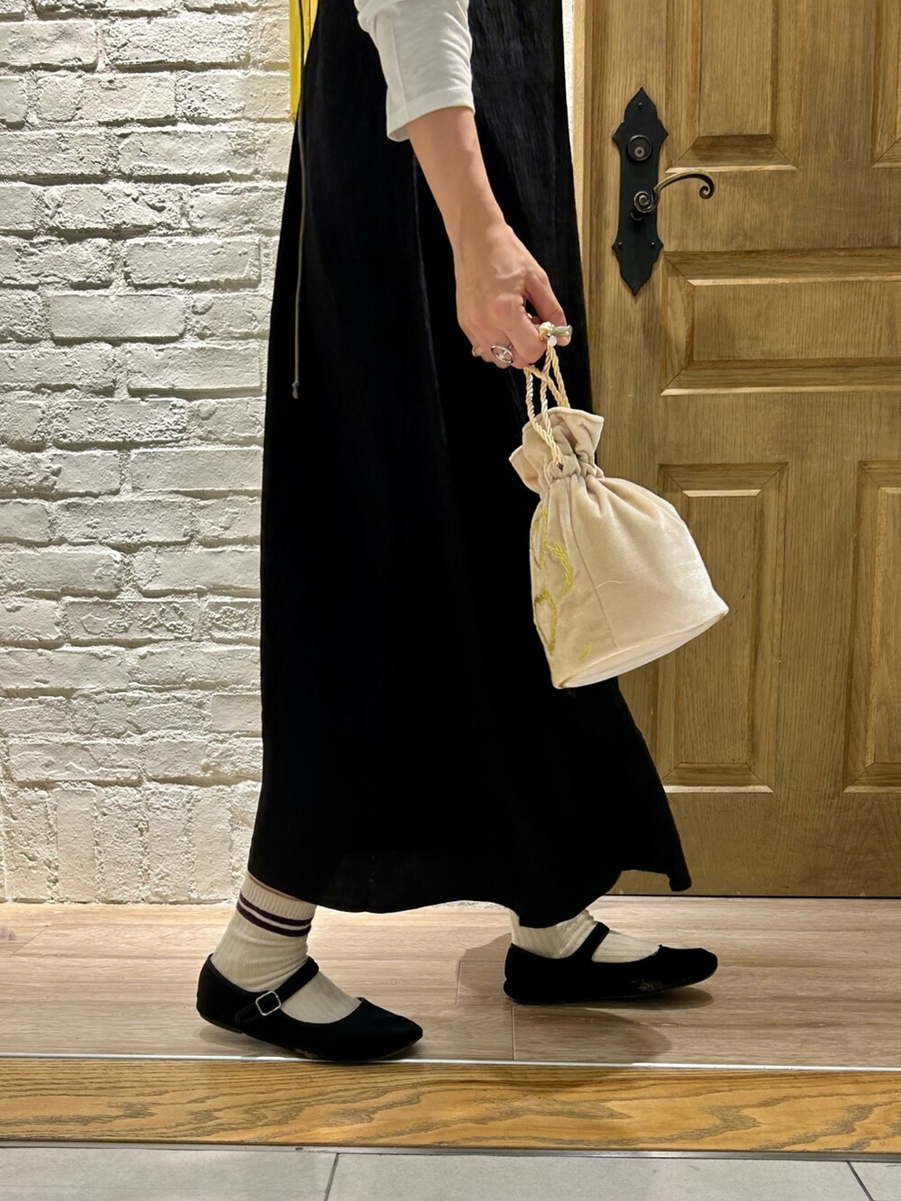 ホワイト系のTシャツ/カットソー、ブラック系のワンピース、ホワイト系のショルダーバッグを着用したレディースの夏コーディネートの2枚目の写真