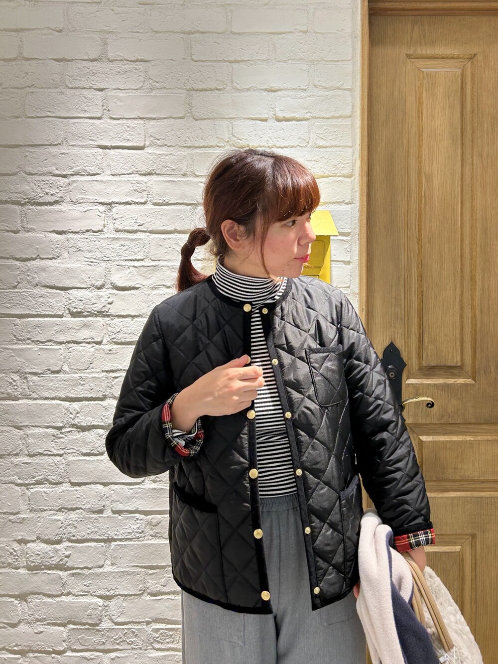 ホワイト系のトートバッグ、ホワイト系のTシャツ/カットソー、ブラック系のブルゾンを着用したレディースの冬コーディネートの2枚目の写真