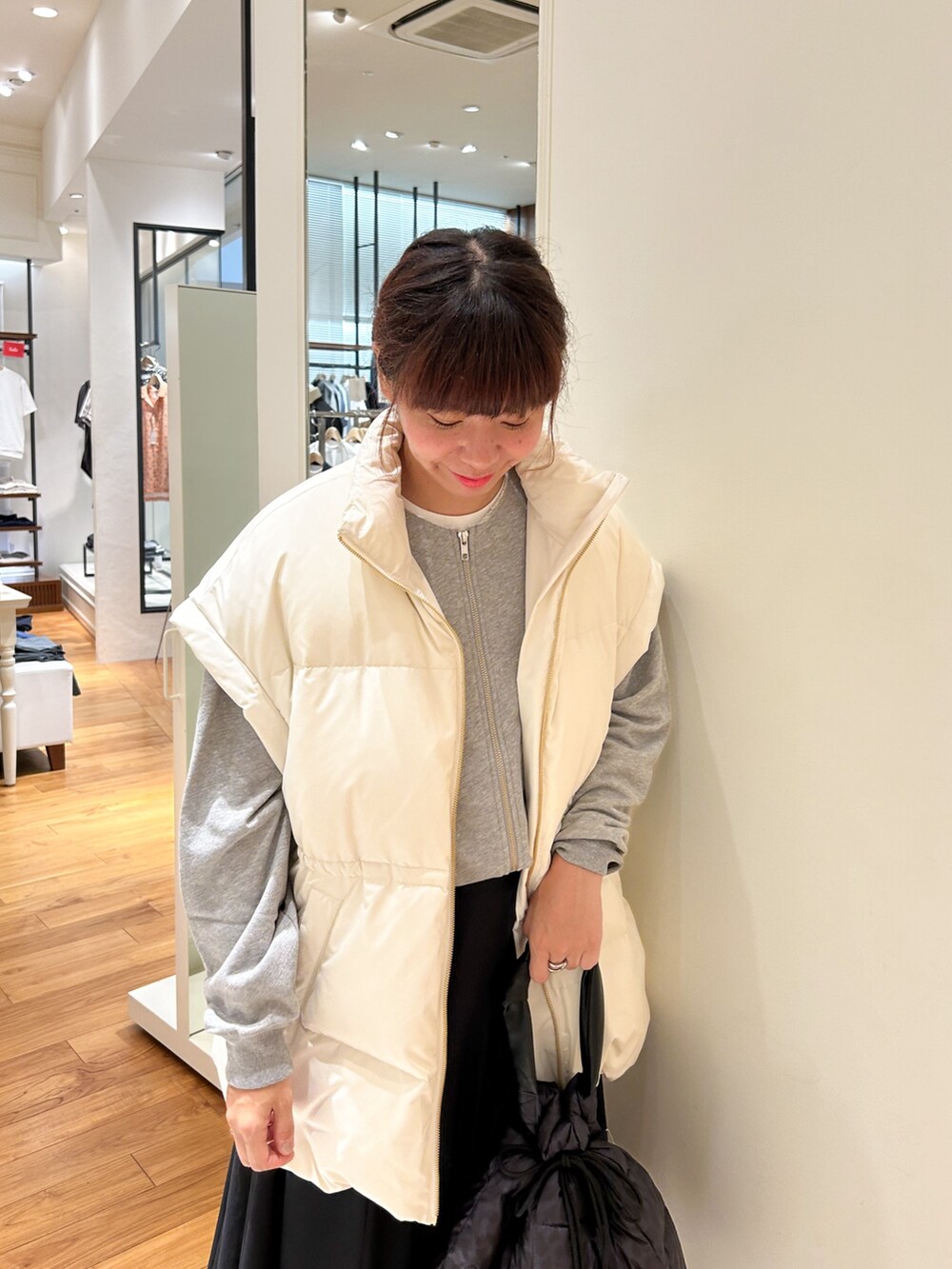 ホワイト系のダウンベスト、グレー系のブルゾン、ブラウン系のショルダーバッグを着用したレディースの夏コーディネートの4枚目の写真