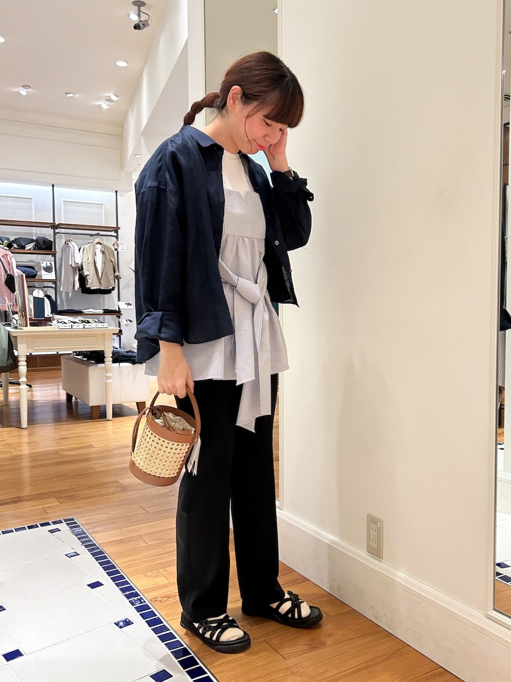 ブラック系のシャツ/ブラウス、ブルー系のTシャツ/カットソー、ベージュ系のトートバッグを着用したレディースの春コーディネートの2枚目の写真