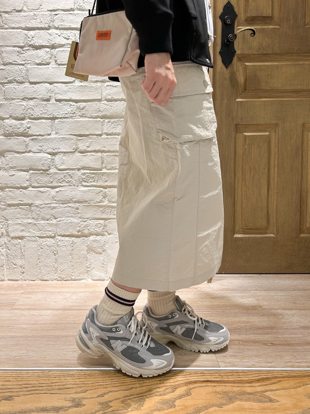 ベージュ系のスカート、グレー系のスウェット、ブルー系のシャツ/ブラウスを着用したレディースの春コーディネートの3枚目の写真