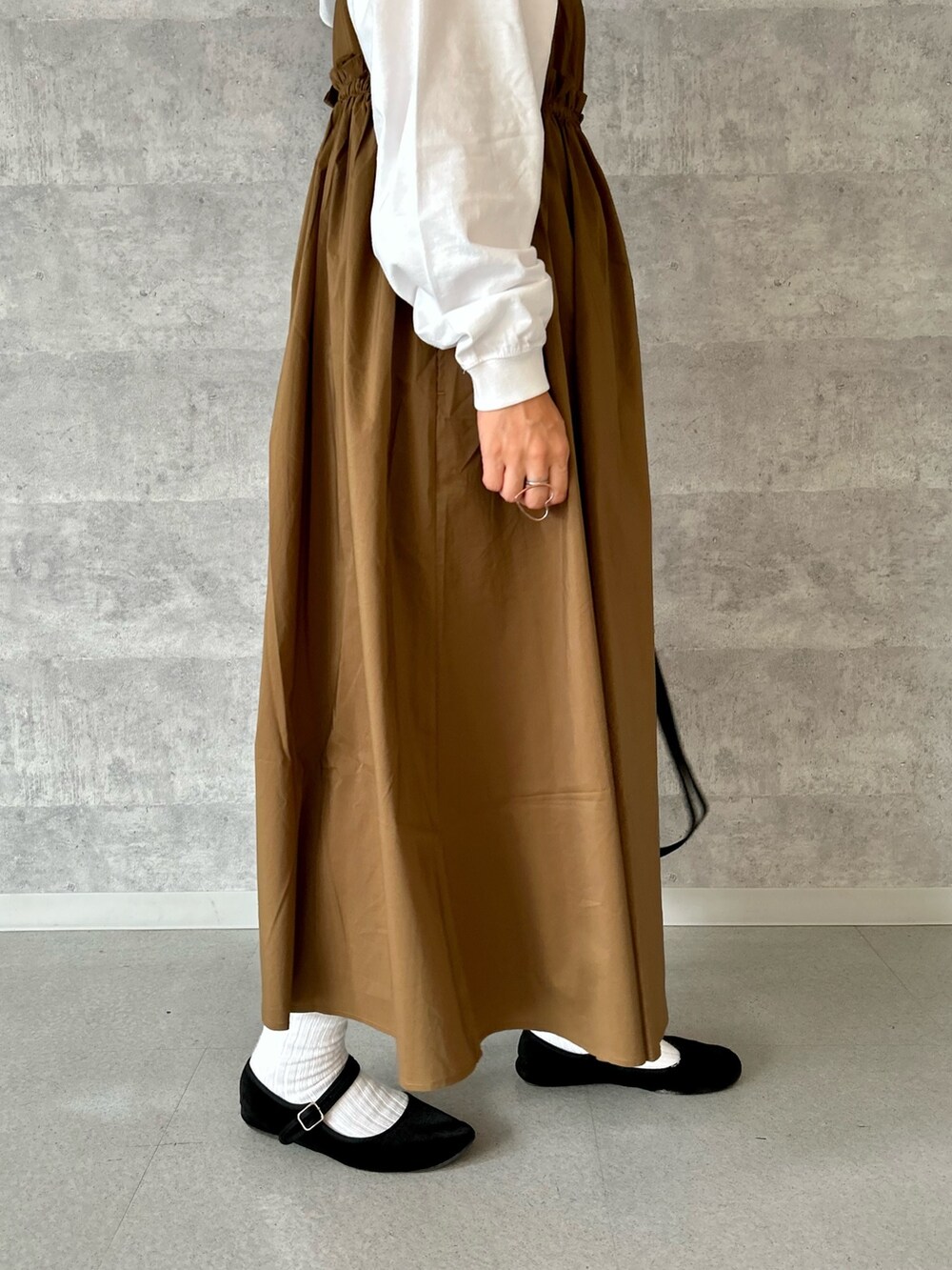 ブラック系のショルダーバッグ、イエロー系のワンピース、ホワイト系のTシャツ/カットソーを着用したレディースの秋コーディネートの3枚目の写真