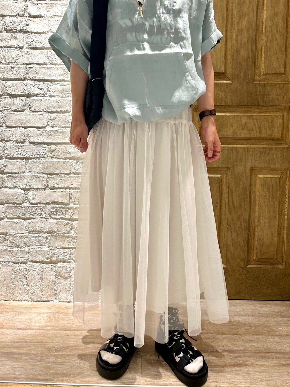 グレー系のTシャツ/カットソー、ブルー系のブルゾン、ホワイト系のスカートを着用したレディースの夏コーディネートの3枚目の写真