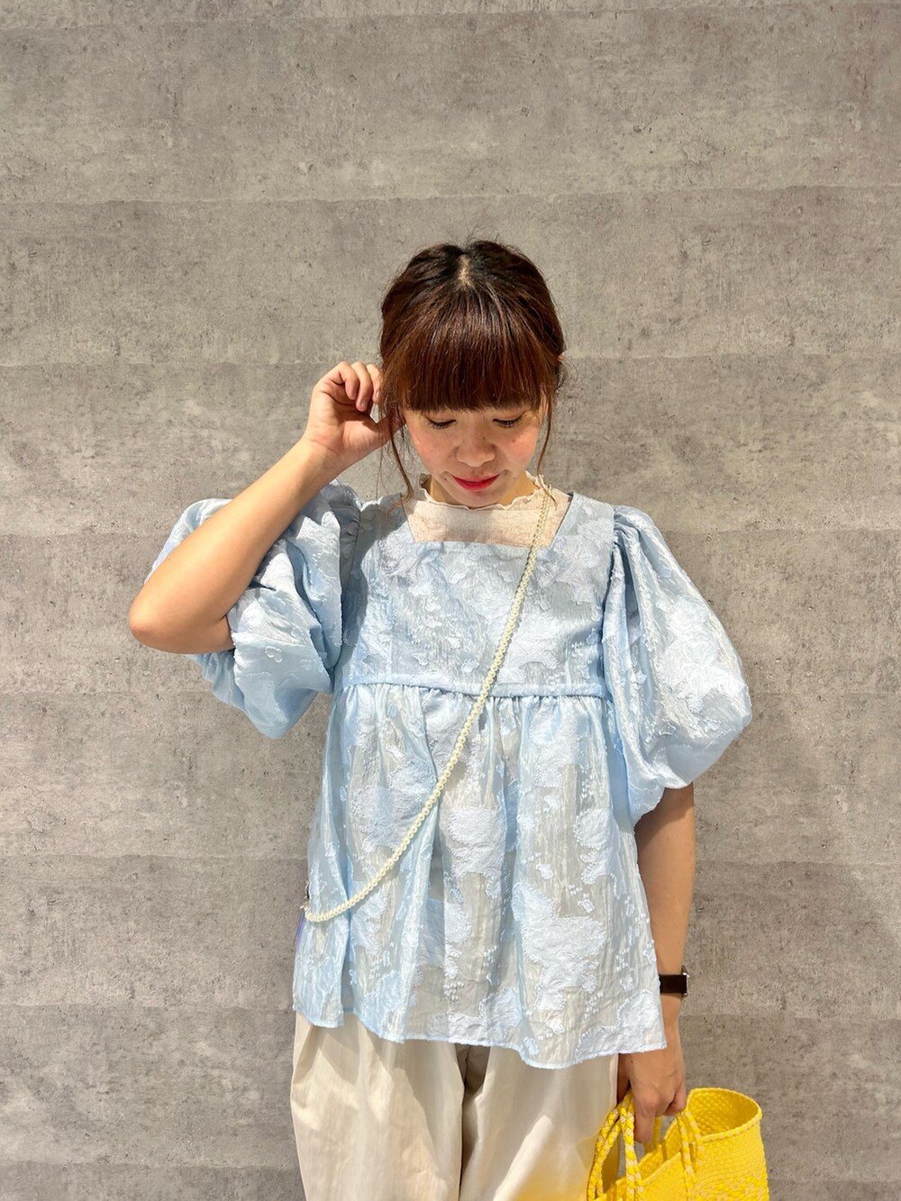 ブルー系のシャツ/ブラウス、ホワイト系のその他パンツ、イエロー系のトートバッグを着用したレディースの春コーディネートの2枚目の写真