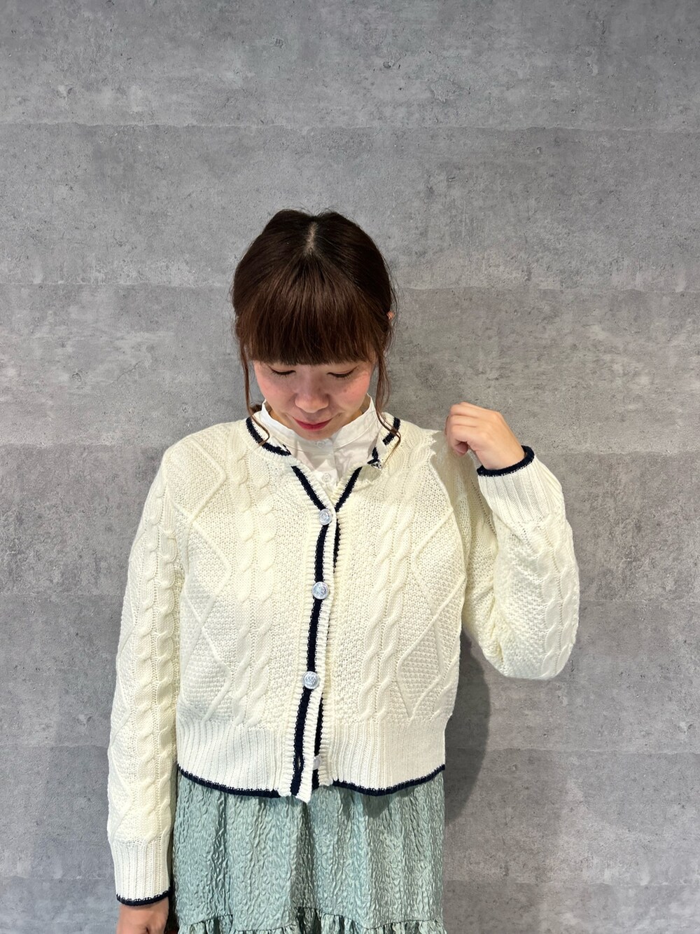 ホワイト系のカーディガン/ボレロ、ブラック系のショルダーバッグ、グリーン系のスカートを着用したレディースの冬コーディネートの2枚目の写真