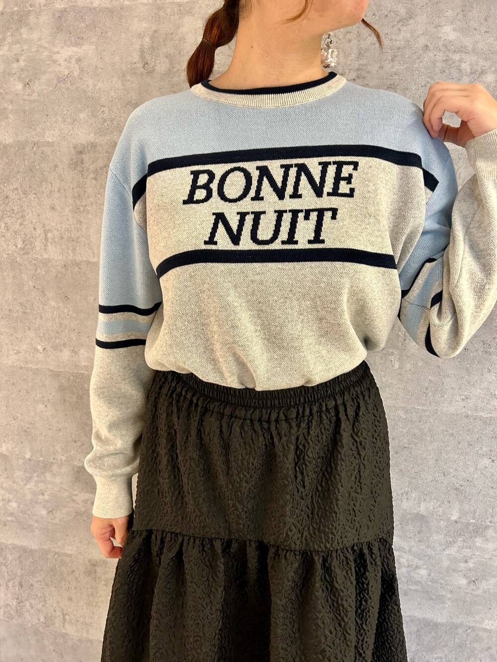 ホワイト系のスニーカー、ブラック系のスカート、イエロー系のトートバッグを着用したレディースの冬コーディネートの3枚目の写真