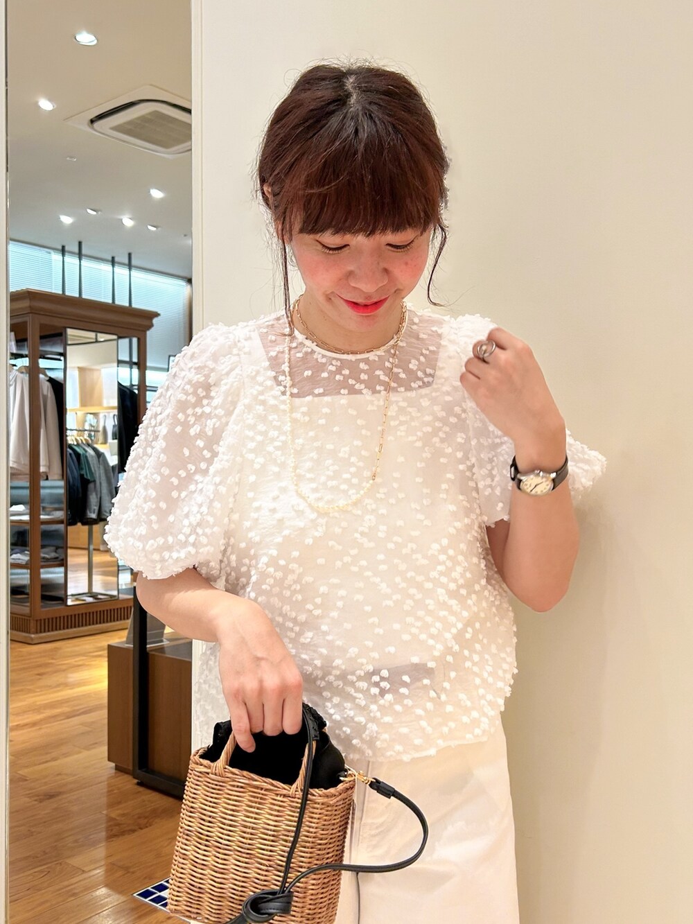 イエロー系のかごバッグ、ホワイト系のデニムパンツ、ホワイト系のシャツ/ブラウスを着用したレディースの春コーディネートの3枚目の写真