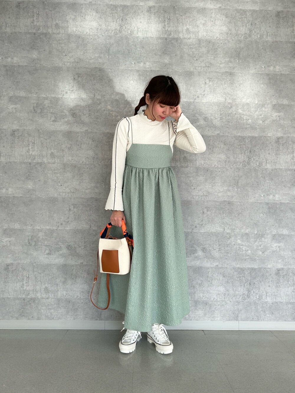 ホワイト系のTシャツ/カットソー、ブルー系のデニムジャケット、グリーン系のワンピースを着用したレディースの冬コーディネートの3枚目の写真