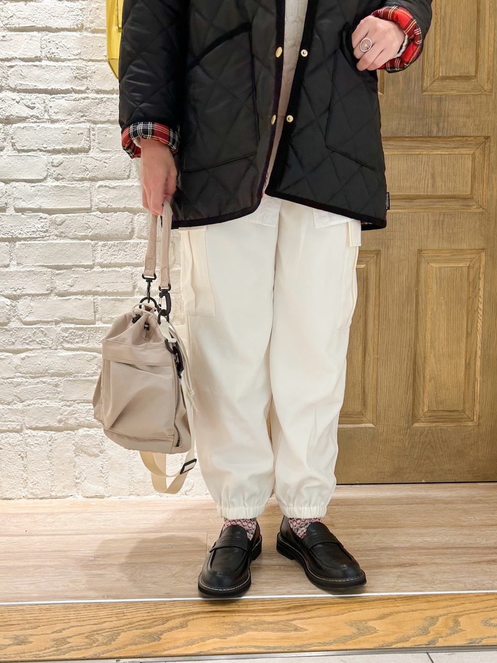 ブラック系のローファー、ホワイト系のシャツ/ブラウス、ホワイト系のニット/セーターを着用したレディースの冬コーディネートの3枚目の写真