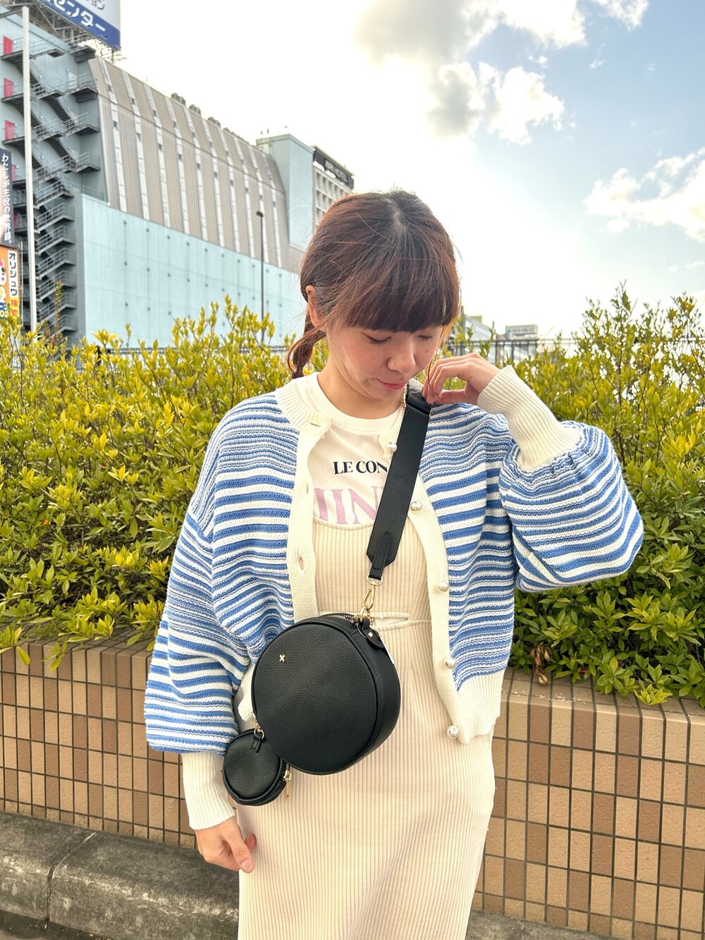 ホワイト系のTシャツ/カットソー、ブラック系のショルダーバッグ、ホワイト系のワンピースを着用したレディースの冬コーディネートの2枚目の写真