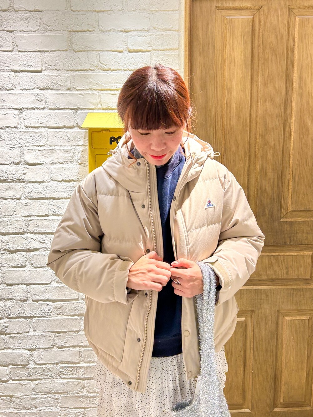 グレー系のTシャツ/カットソー、ベージュ系のダウンジャケット/コート、ブルー系のスウェットを着用したレディースの秋コーディネートの2枚目の写真