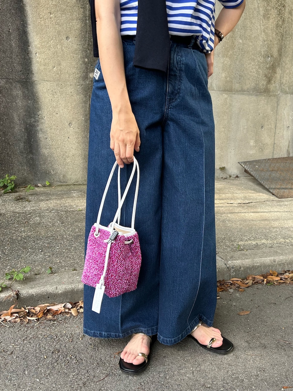 ブルー系のTシャツ/カットソー、ブラック系のカーディガン/ボレロ、ブルー系のデニムパンツを着用したレディースの春コーディネートの4枚目の写真