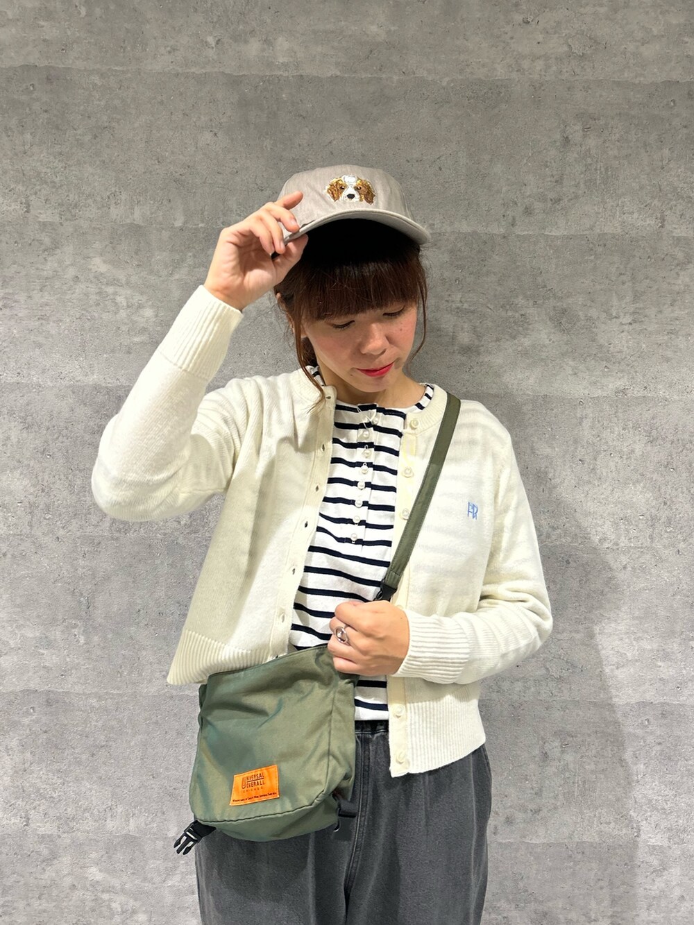 グレー系のデニムパンツ、グリーン系のショルダーバッグ、ブルー系のTシャツ/カットソーを着用したレディースの秋コーディネートの2枚目の写真